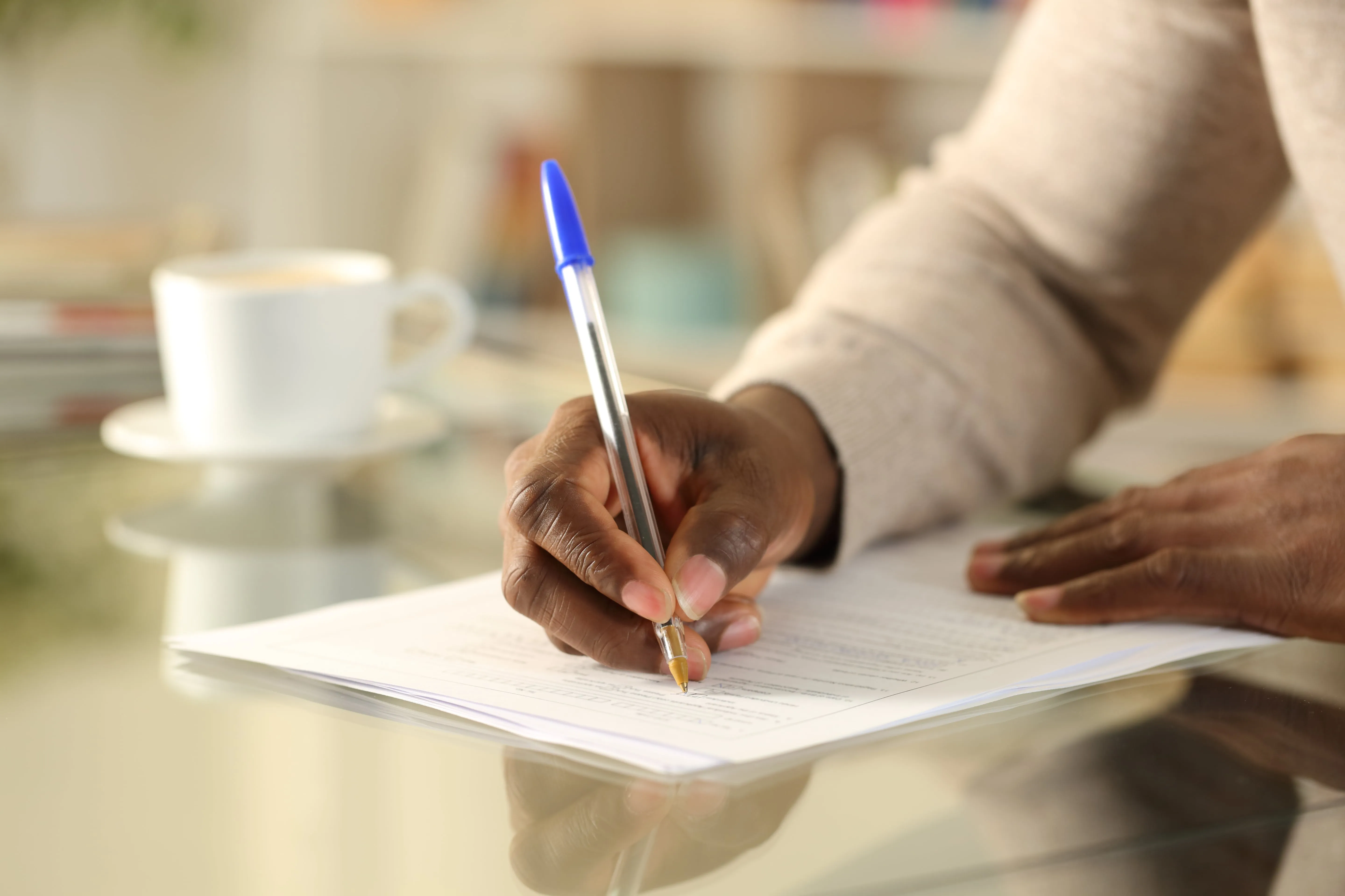 a closeup of a man filling out paper work for their new home