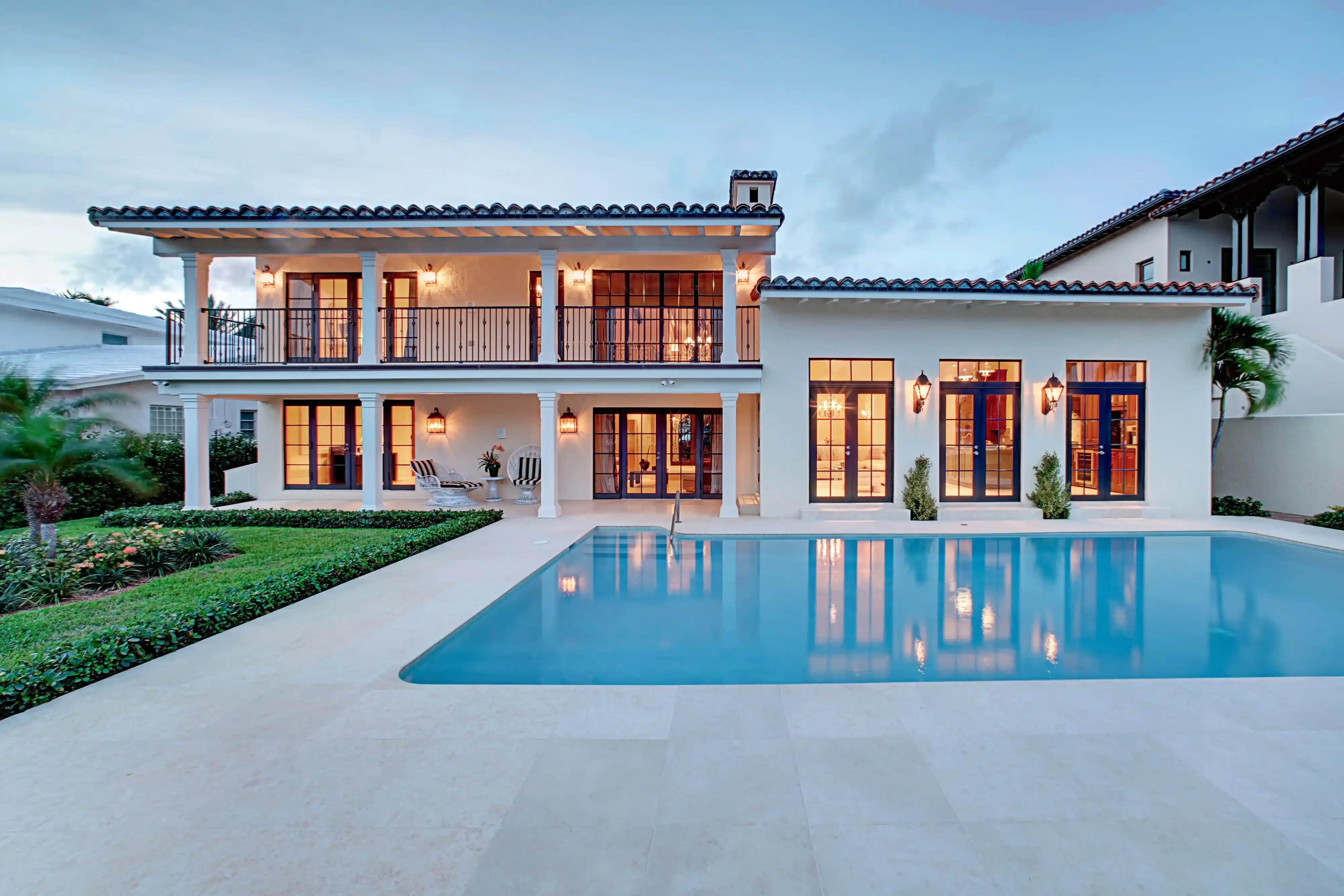 Twilight view of a luxury home with pool in the foreground