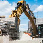 Mechanical digger demolishing building.