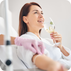 Attractive dark-haired woman smiling during the intravenous therapy