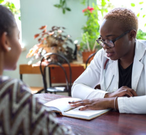 doctor explaining information from the book to a woman