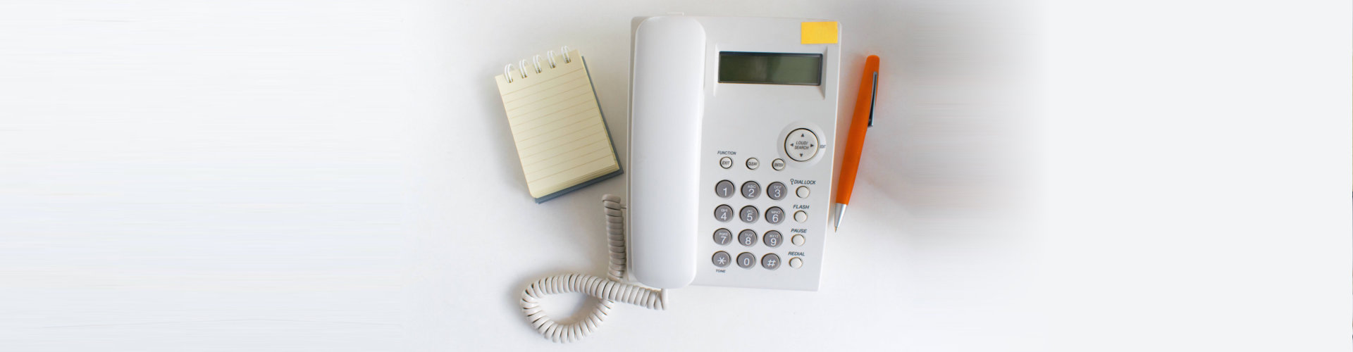 pen and notebook beside the telephone