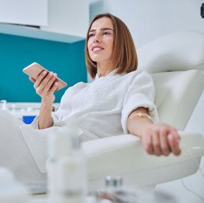 woman holding a phone while on dextrose