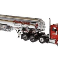 A red and silver truck is parked next to the tanker trailer.