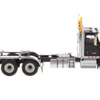 A black and white truck is parked on the side of the road.
