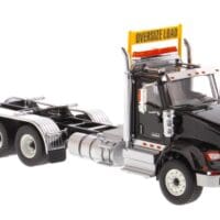A black and white truck with an oversize load sign.
