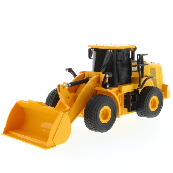 A yellow and black toy tractor is on the floor