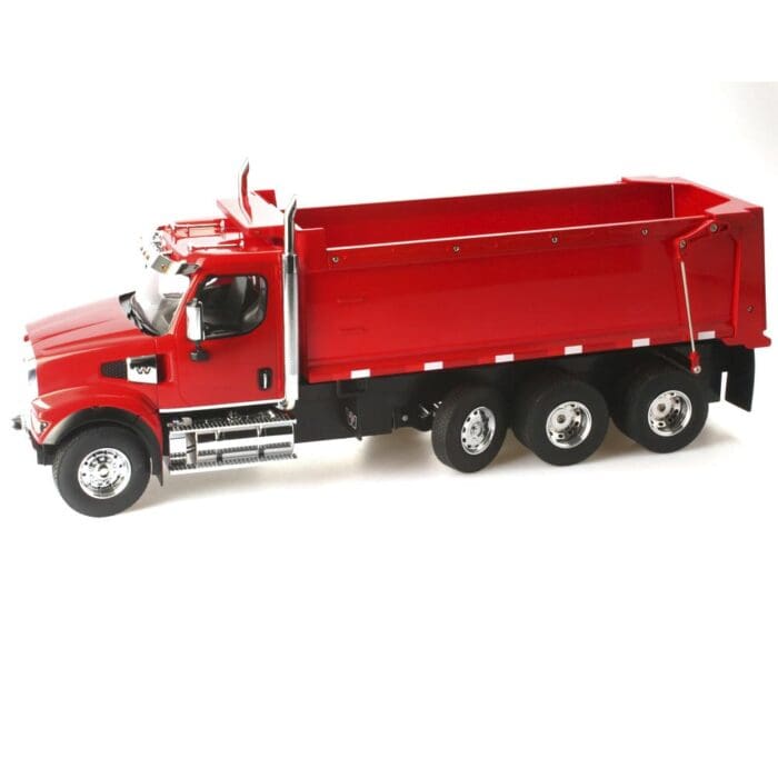 A red dump truck is parked on the side of the road.